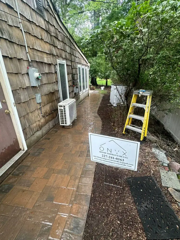 Brick flooring surrounded by a home and trees