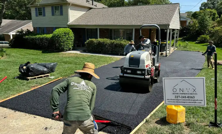 Steam roller compacting a new residential asphalt driveway