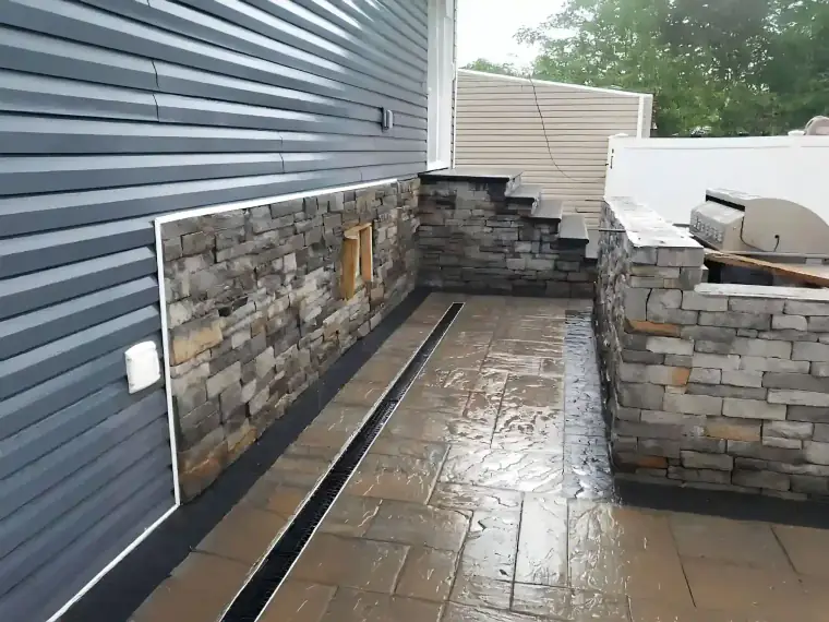 Stainless steel BBQ pit enclosed by stone retaining walls
