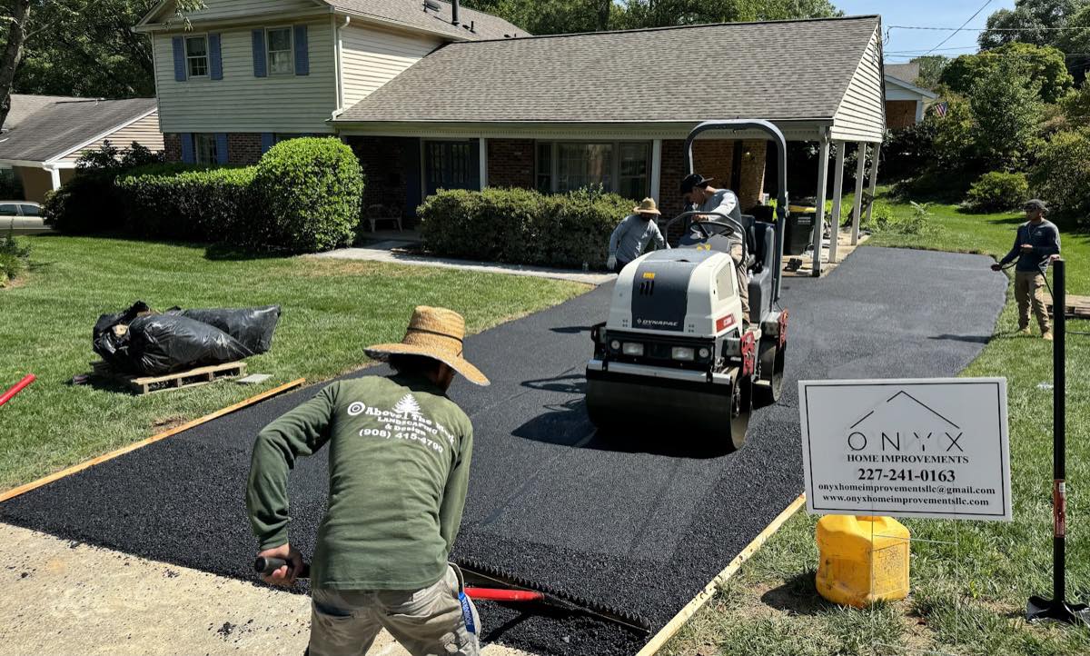 Onyx crew compacting a freshly laid asphalt driveway with a ride-on roller at a Springfield home