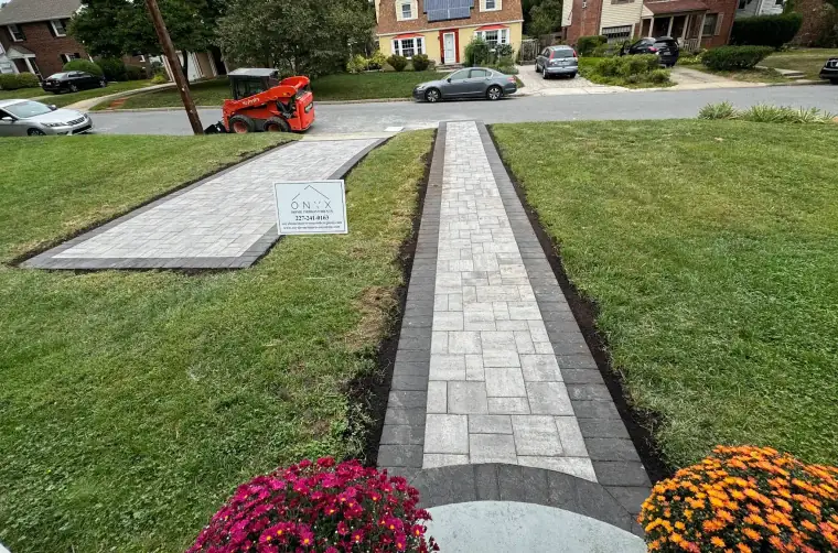 Paver walkway lined with flowers leading to a home