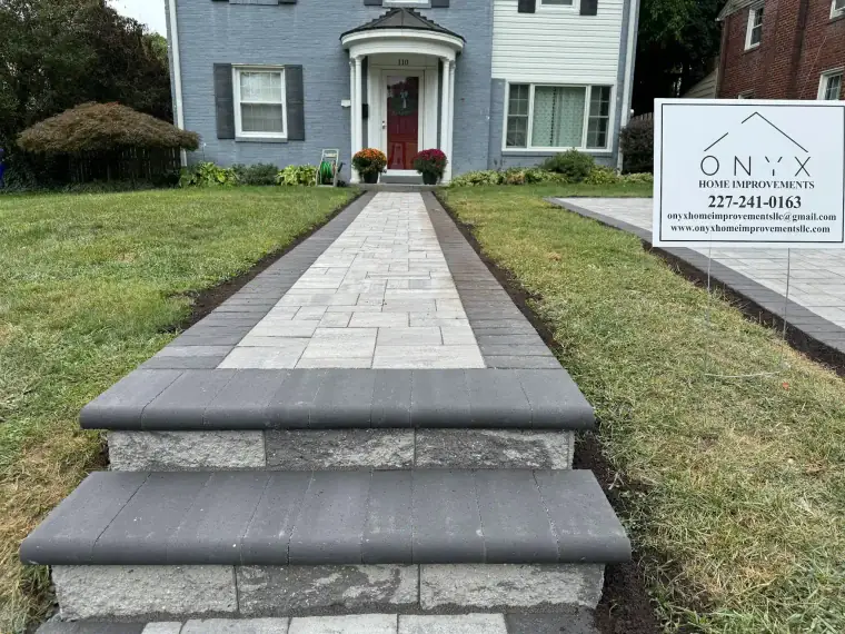 Paver walkway with wide stone steps leading to a front entry