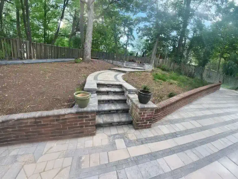 Long brick retaining wall terracing a backyard