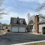 Two story home and garage side by side on a bright sunny day.