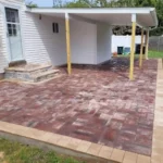 Backyard brick paved patio with awning in the background.