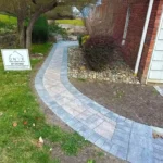 Brick walkway on the side of a brick house.