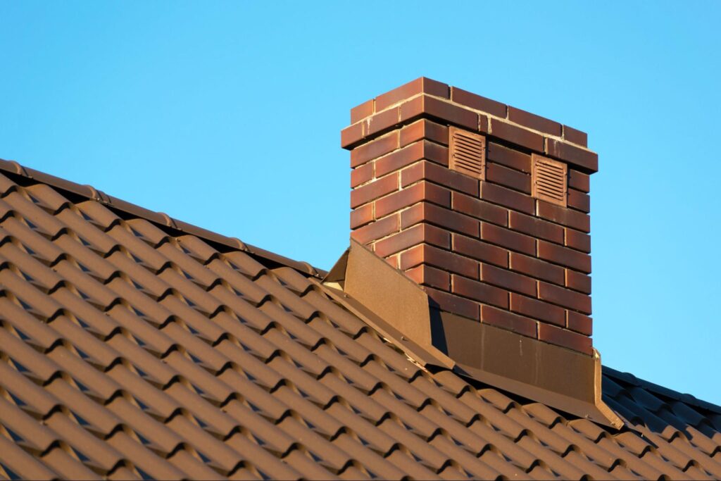 A rooftop brick chimney with a blue sky in the background