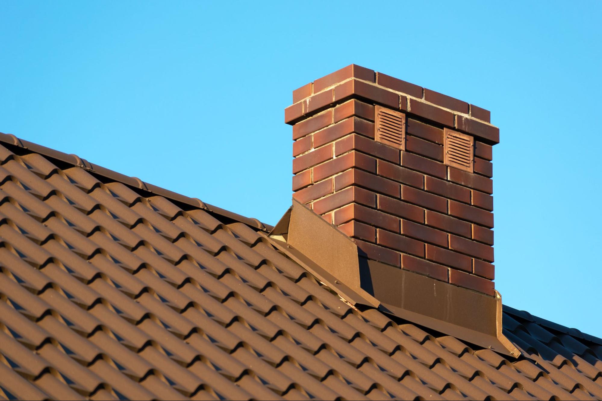 A rooftop brick chimney with a blue sky in the background
