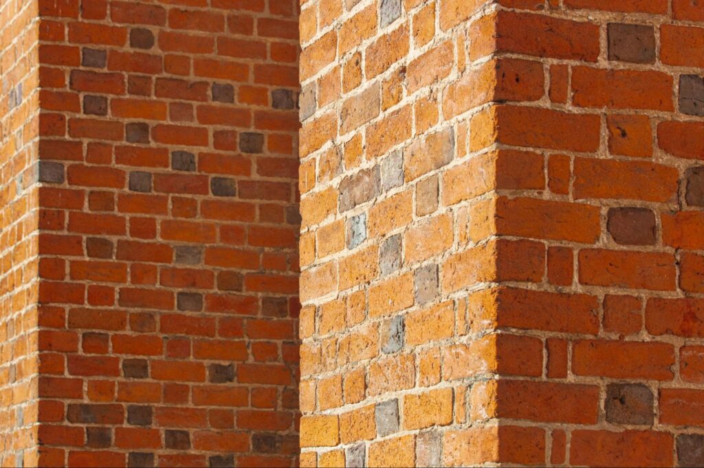 Architectural detail showing corners and shadows of red brickwork on a cathedral wall.