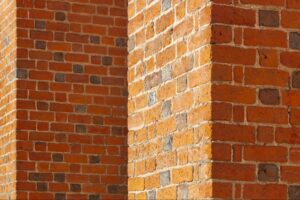 Architectural detail showing corners and shadows of red brickwork on a cathedral wall.
