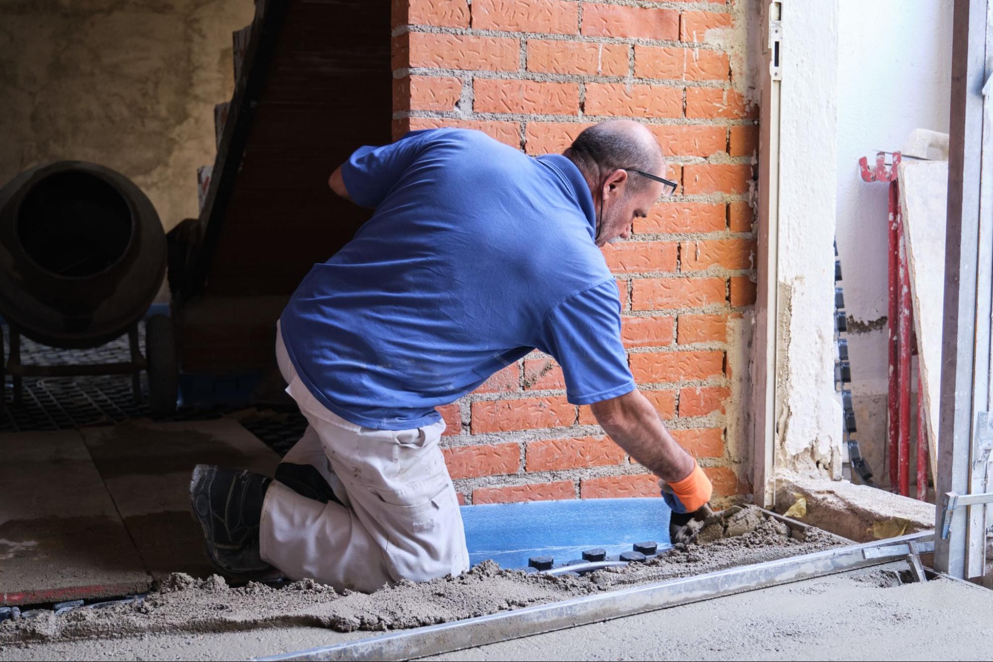 A foundation repair contractor levels fresh concrete over a reinforced base.