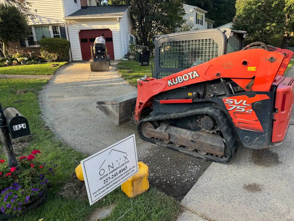 Concrete driveway paving underway as a road roller compacts and smooths the fresh surface.