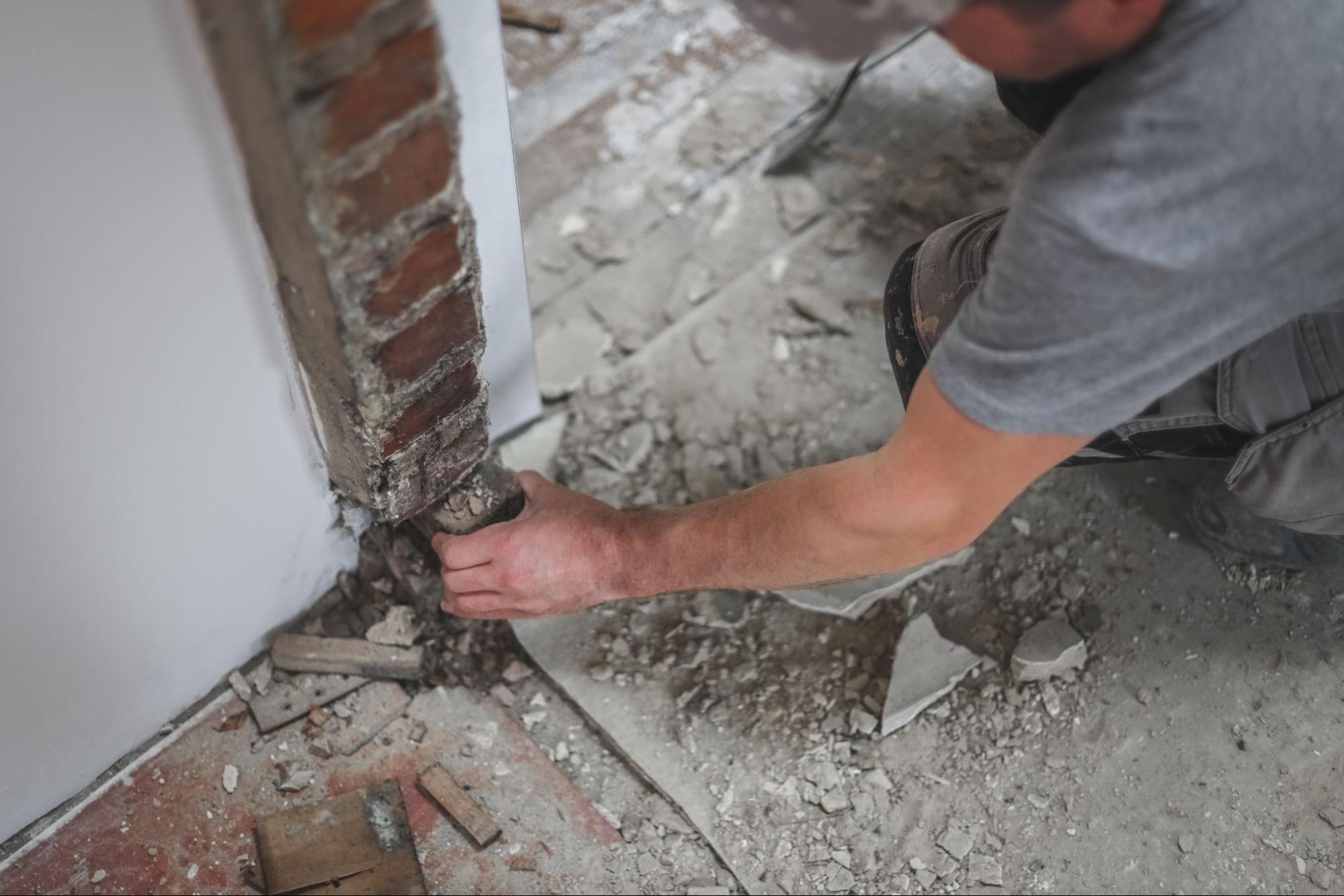A foundation repair contractor fixes concrete cracks near the doorway.
