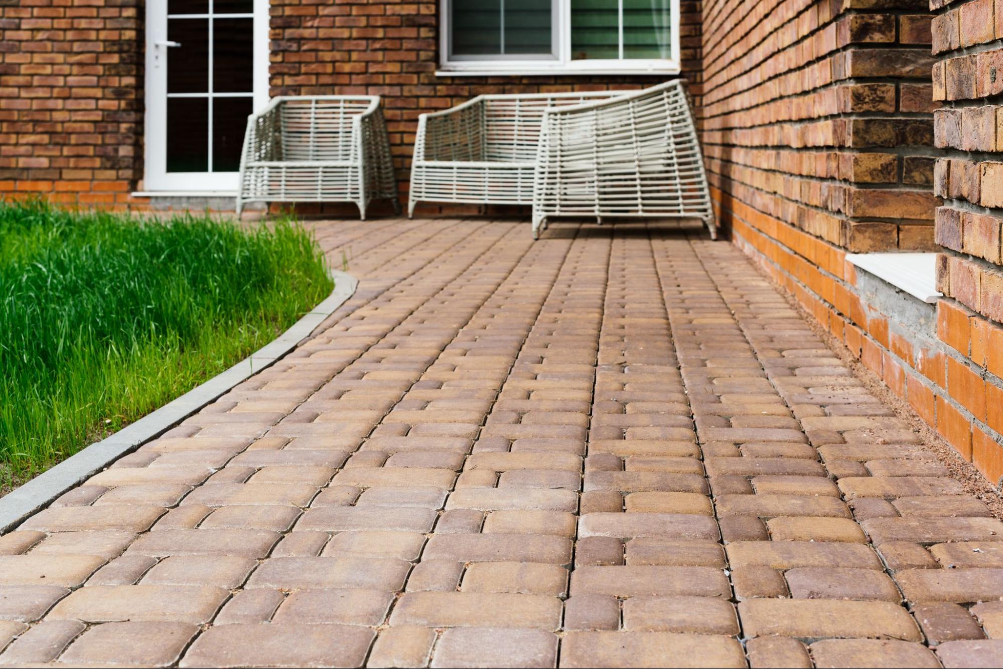 Wide view of a custom patio paver design featuring wicker furniture.