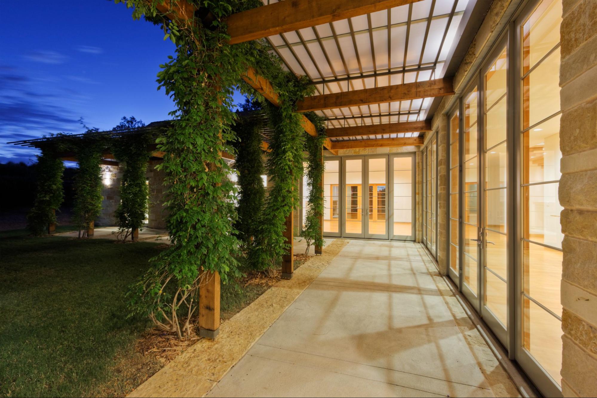 A covered concrete walkway along the side of a modern home.