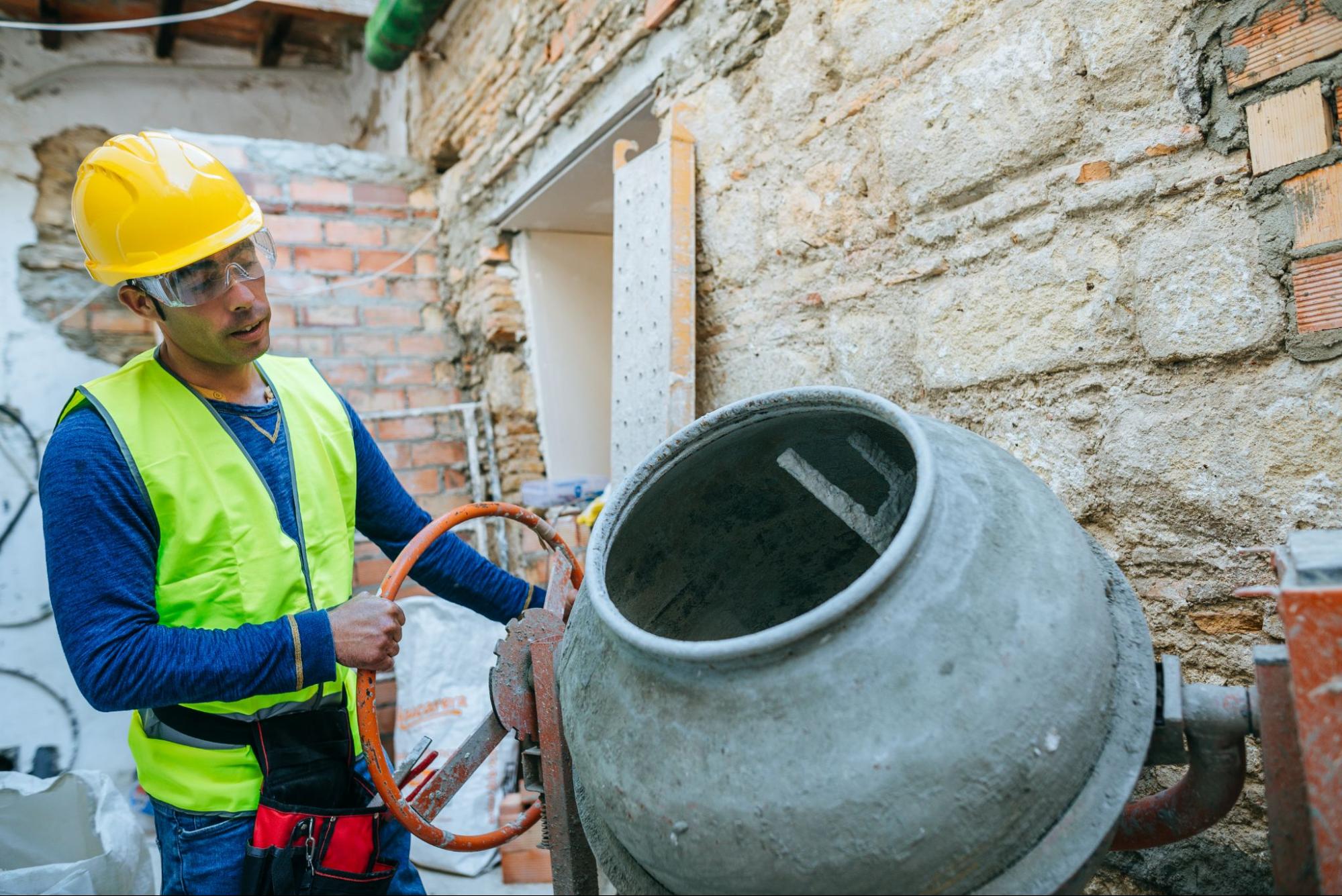 A masonry contractor on a jobsite working with a cement mixer.