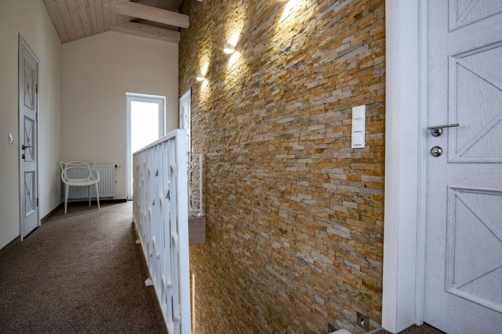 Contemporary home interior with a wide hallway and decorative stone work accent wall