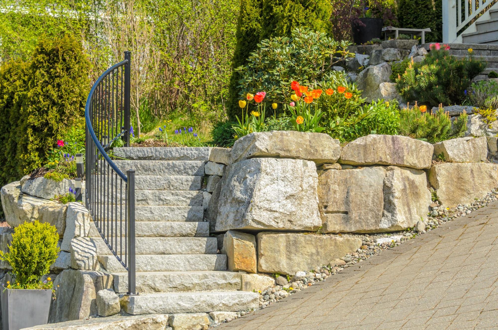 Stone stairs next to flowers in front of a home.